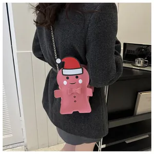 Pink gingerbread man crossbody bag with gold chain strap on grey tweed coat detail
