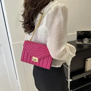 Magenta quilted shoulder bag with gold chain strap and rectangular metal lock for women