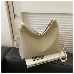 Detail of sage green hobo tote bag with cream piping and adjustable shoulder strap