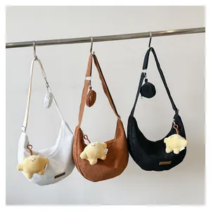 Detailed row of corduroy crossbody bags in white, brown, and black with star pendants
