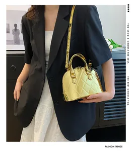 Close-up of golden shell bag with diamond quilted texture and round metal handle