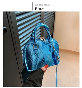 Close-up of bright blue shell bag with diamond quilt stitching and golden hardware
