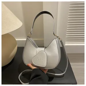 Close-up of silver hobo bag featuring a heart-shaped LOVE embossed flap and metal hardware