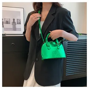 Detail of neon green patent leather shell bag with quilted rhombic pattern and top handles