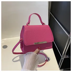 Schicke kleine viereckige Handtasche in Rosenrot aus Leder mit goldenem Metallstab