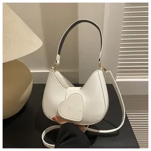 Detail of white half-moon hobo bag with heart flap and LOVE embossed texture