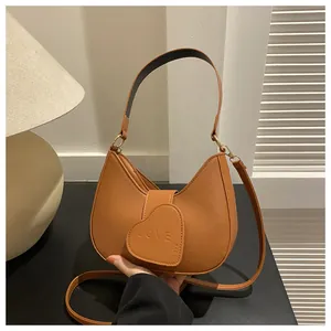 Detail view of caramel brown hobo bag with heart LOVE embossing and detachable strap