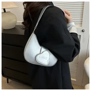 Detail view of silver heart-shaped shoulder bag with LOVE embossing in Y2K style