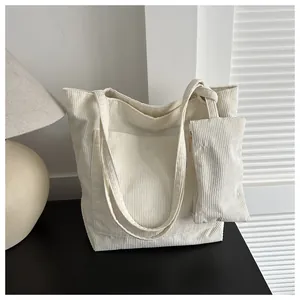 Detail eines großen Cord-Shopper-Sets mit passender Reißverschlusstasche auf schwarzem Tisch
