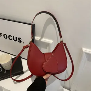 Deep red crescent leather handbag with heart-shaped LOVE flap and gold hardware