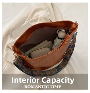 Internal capacity of brown leather tote bag with colorful ethnic patterned shoulder strap