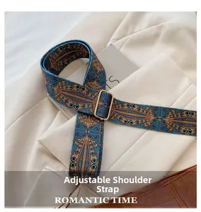 Adjustable blue embroidered shoulder strap with ethnic geometric patterns and gold buckles