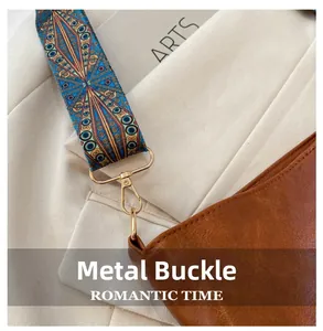 Detail of golden hardware hook on brown leather bag with ethnic woven shoulder strap