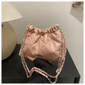 Détail du sac seau rose matelassé avec logo argenté JINGPIN et bandoulière en chaîne