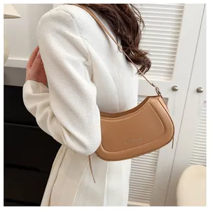 Vue latérale d'un sac bandoulière croissant en cuir marron avec bandoulière réglable