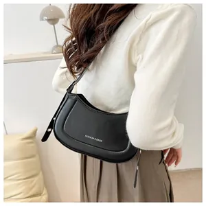 Détail du sac bandoulière noir en demi-lune avec lettrage blanc et coutures précises
