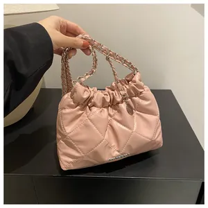 Détail du sac seau rose matelassé avec bandoulière chaîne argentée et logo en métal
