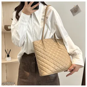 Detail view of khaki quilted tote bag showing diamond texture and slim shoulder straps