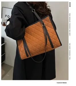 Close-up of caramel quilted tote bag with black trim and elegant rhombus embroidery