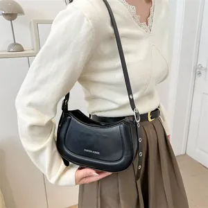 Sac bandoulière demi-lune en cuir noir porté par un mannequin pour le style et la taille