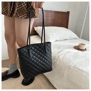 Close-up of quilted pattern and texture on a black faux leather tote bag for women