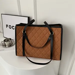 Brown quilted tote bag with large capacity and elegant gold metal ring accents