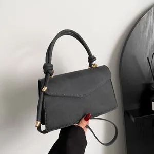 Chic dark grey gradient envelope bag with knotted handle and golden hardware on a shoulder strap