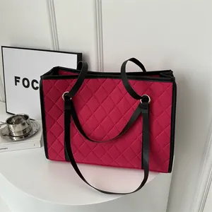 Quilted rose red tote bag with black leather handles and spacious interior design
