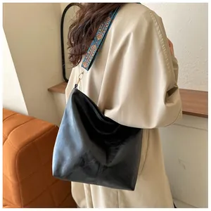 Detail of black leather tote bag with ethnic geometric pattern wide shoulder strap