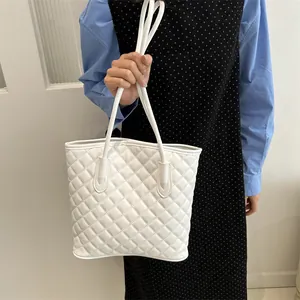 Chic white quilted tote bag with dual straps shown in a stylish lifestyle setting