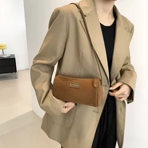 Sac cylindrique chic en daim marron pour femme avec un design minimaliste et rétro