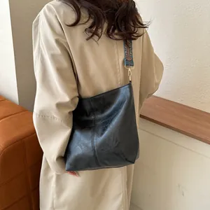 Large black textured faux leather tote bag with colorful bohemian wide shoulder strap
