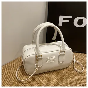 Detail of white rectangular Boston bag with embossed FAS HON text and gold hardware
