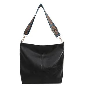 Black soft leather tote bag with a colorful ethnic pattern wide shoulder strap