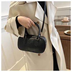 Detail of black leather handbag with FASHION engraving and golden hardware