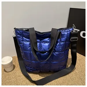 Detail of dark blue quilted tote bag with metallic finish and adjustable shoulder strap