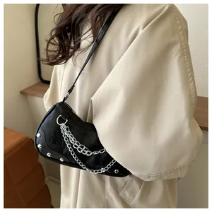 Vue latérale du sac demi-lune noir texture croco avec chaînes argentées et clous