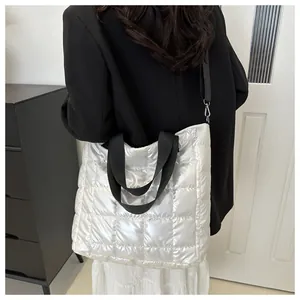 Silver quilted tote bag shown as cross-body on model, metallic waterproof fabric detail