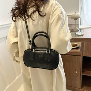 Minimalist black leather cylinder handbag with adjustable strap for casual outfits