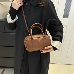 Brown leather Boston bag with embossed lettering and adjustable shoulder strap