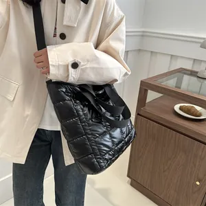 Minimalist black quilted tote bag with padded diamond stitch and wide shoulder straps