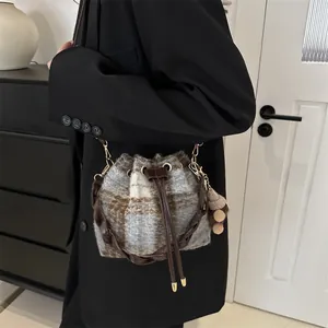 Vintage checkered drawstring bucket bag with plush charm and woven leather handle