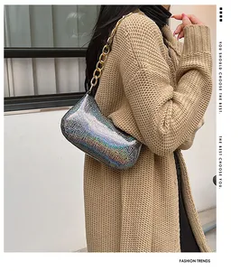 Detail of glitter finish shoulder bag with gold chunky chain strap on a model