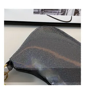 Detail showing shiny silver mesh fabric and gold ring hardware on stylish shoulder bag
