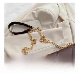 Detail of the brown quilted handbag with gold-tone chain and leather shoulder strap