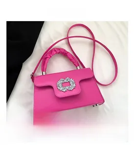 Detailed close-up of fuchsia handbag with rhinestone buckle and pleated handle