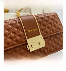 Detail of brown quilted leather bag with gold buckle and fashion strap embroidery