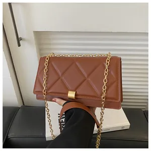 Detail of caramel brown quilted shoulder bag with gold chain and metal clasp