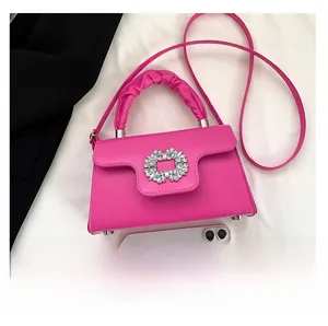 Detail of rose pink handbag with sparkling rhinestone buckle and ruched top handle