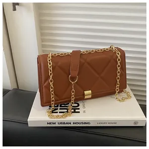 Detail of a brown quilted leather shoulder bag featuring a gold chunky chain strap